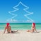 Lovers couple in santa hats at tropical sandy beac