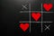 Lovers day concept. tic-tac-toe game where instead of zeroes are red hearts. on a black background. horizontal