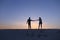 Lovers hold each other arms and swirl on sandy hill in desert on