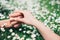 Lovers holding hands on spring flowers field