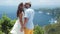 Lovers kiss on background of beautiful view of ocean from mountain, slow motion