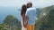 Lovers kiss on background of beautiful view of ocean from mountain, slow motion