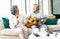 Lovers in a living room.Funny portrait of smiling senior man playing guitar and her wife holding maracas dancing and sitting sofa