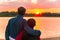 Lovers mature time stands hugging and looks at the sunset from