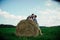 Lovers resting in a field near haystacks