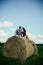 Lovers resting in a field near haystacks