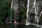 Lovers at the waterfall. Couple admiring a beautiful waterfall in Indonesia. Couple on vacation in Bali. Honeymoon trip.