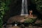 Lovers at the waterfall. Couple admiring a beautiful waterfall in Indonesia. Couple on vacation in Bali. Honeymoon trip.
