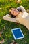 She loves her tunes. An attractive young woman listening to music on her digital tablet while outdoors.