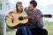 She loves learning from dad. a young father teaching his daughter to play the guitar at home.