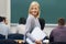 She loves learning. A young female student standing in the classroom.