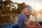 He loves the solitude of the river. a mature man rowing a boat on a lake.