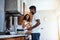 She loves watching him cook. Cropped shot of a handsome young man cooking in the kitchen while his wife watches on.