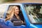 She loves the wind in her hair. A young woman feeling the wind in her hair through an open car window.