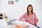 She loves working in a creative environment. Portrait of a young woman sitting at a desk.