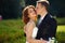 Lovesong - groom kisses a bride tenderly standing in the green p