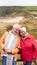 Loving Active Senior Couple Resting By Gate As They Walk Along Coastal Path In Winter