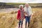 Loving Active Senior Couple Walking Arm In Arm Through Sand Dunes On Winter Beach Vacation