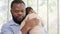 Loving African American dad embracing baby and baby girl sleeping on stepfather shoulder. Happy family with pleasure spending time