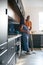 Loving African American Husband With Pregnant Wife At Home In Kitchen Together