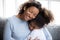 Loving African American mother embracing with daughter
