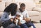 Loving afro parents tickling their little daughter, having fun at home