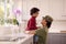 Loving American Army Mother In Uniform Home On Leave With Son In Family Kitchen
