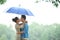 Loving Asian Couple in Rain under Umbrella