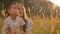 Loving asian family, cute boy and his mother talking happily and pointing while sitting in yellow grass on field