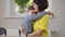 Loving autistic son hugging mother sitting with parent at table indoors. Portrait of cute Caucasian boy with birth