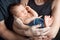 Loving baby sleeping in parents hands. Closeup picture. Happy mother and father and they slipping newborn baby