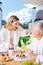 Loving beaming couple wearing white bathrobes having breakfast outside