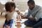 Loving biracial dad play blocks with little daughter