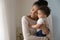 Loving biracial mom hug little baby toddler