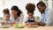 Loving biracial parents teach kids cooking in kitchen