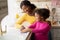 Loving Black Mother Teaching Her Daughter Housekeeping, Cleaning Kitchen Together