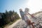 Loving blonde-haired man hugging his stylish woman having rest on beach