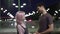 Loving boyfriend talking with girlfriend in slow motion standing outdoors in night city. Side view happy Caucasian man