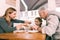 Loving caring grandparents giving their little girl fresh croissant