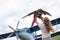 A loving Caucasian woman is playing with her little daughter in airplanes at the airfield. A little girl dreams of