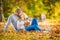 A loving couple in an autumn park lies on the leaves