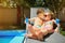 Loving couple child kids on a lounger by the pool in the summer.