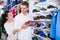 Loving couple deciding on new sneakers in sports store