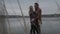 Loving couple hugging and talking as standing behind brown high grass on pier. Happy Caucasian man and woman looking at