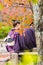 A loving couple in a kimono sits on a bench, Kyoto, Japan. Copy space for text. Vertical.