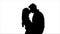 Loving couple look at each other and begin to kiss. Silhouette. White background. Slow motion