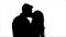 Loving couple look at each other and begin to kiss. Silhouette. White background. Slow motion