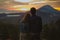 A loving couple, a man and a woman stands near Batur volcano. Sunrise, sunset