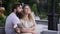 Loving couple in the park on a white bench.