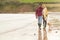 Loving Couple With Pet Dog Hugging Walking Along Beach Shoreline